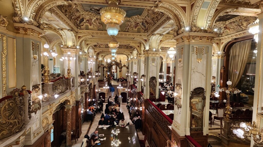 Ornate interior of New York Café in Budapest with gilded ceilings, chandeliers and dining tables
