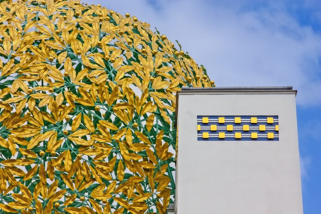 Golden leaf dome of Vienna Secession Building against white architecture